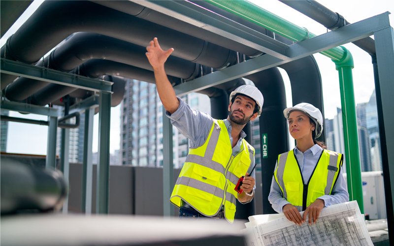 Two professional engineer discuss with blue print of constructio